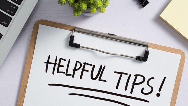 Clipboard with 'HELPFUL TIPS' written on paper, on a desk with a laptop, suggesting strategies for successful student housing investment