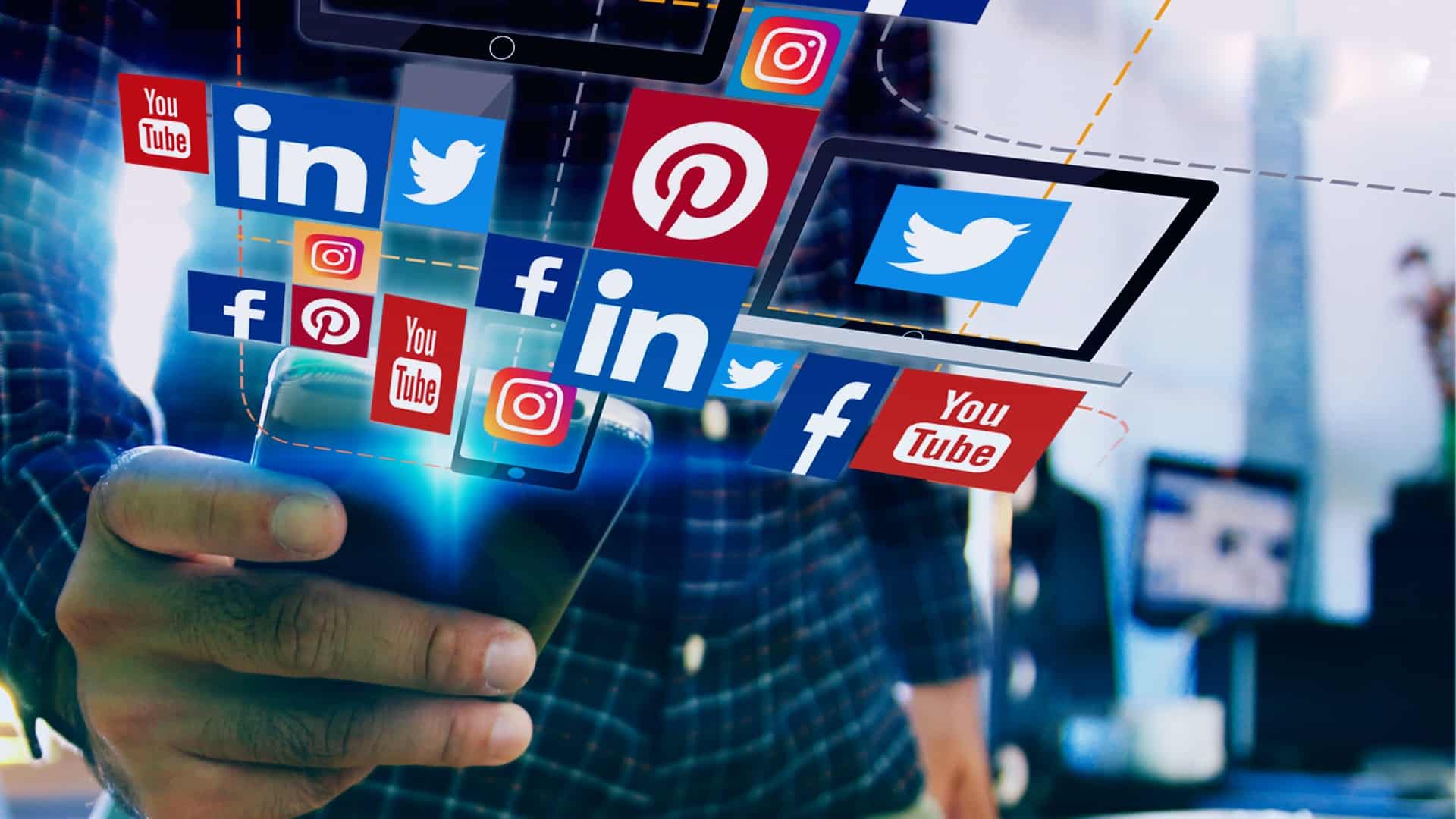 Person holding a smartphone with floating social media icons, including LinkedIn, Twitter, Pinterest, Instagram, Facebook, and YouTube, illustrating the use of social media for real estate investing.