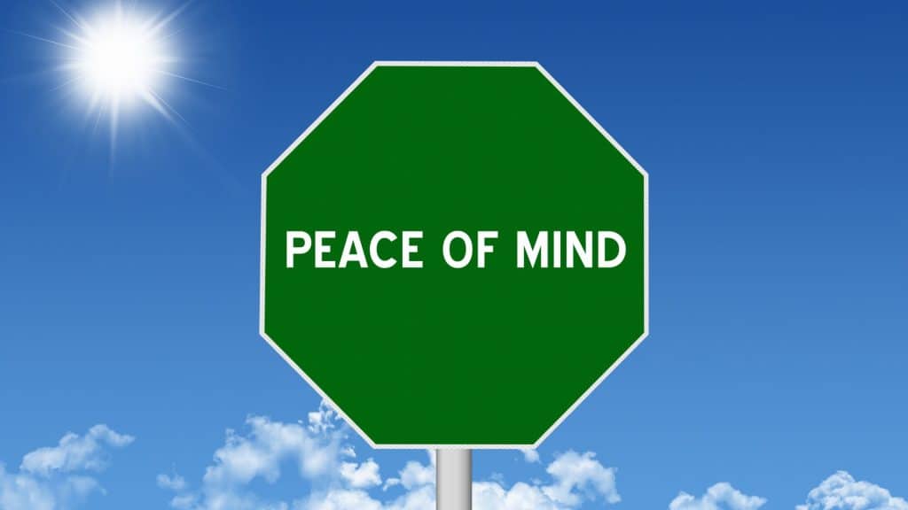 A green octagonal sign with the words 'Peace of Mind' against a clear blue sky, symbolizing the security and reassurance provided by renters insurance.